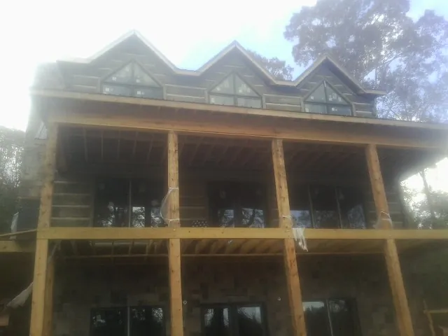 Dormers and porch framing on a large log home under construction — Roof Coating work by our crew in Denham Springs