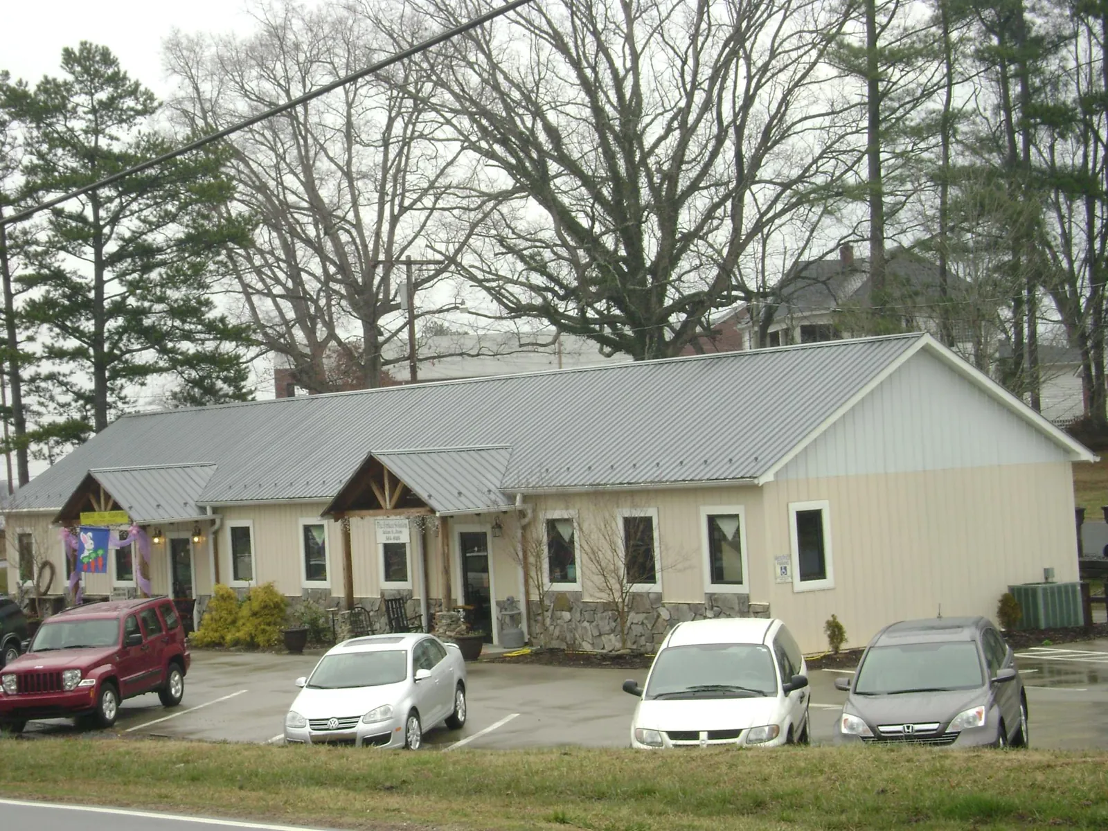 Gray metal roof with timber entry brackets on a small commercial building in Denham Springs