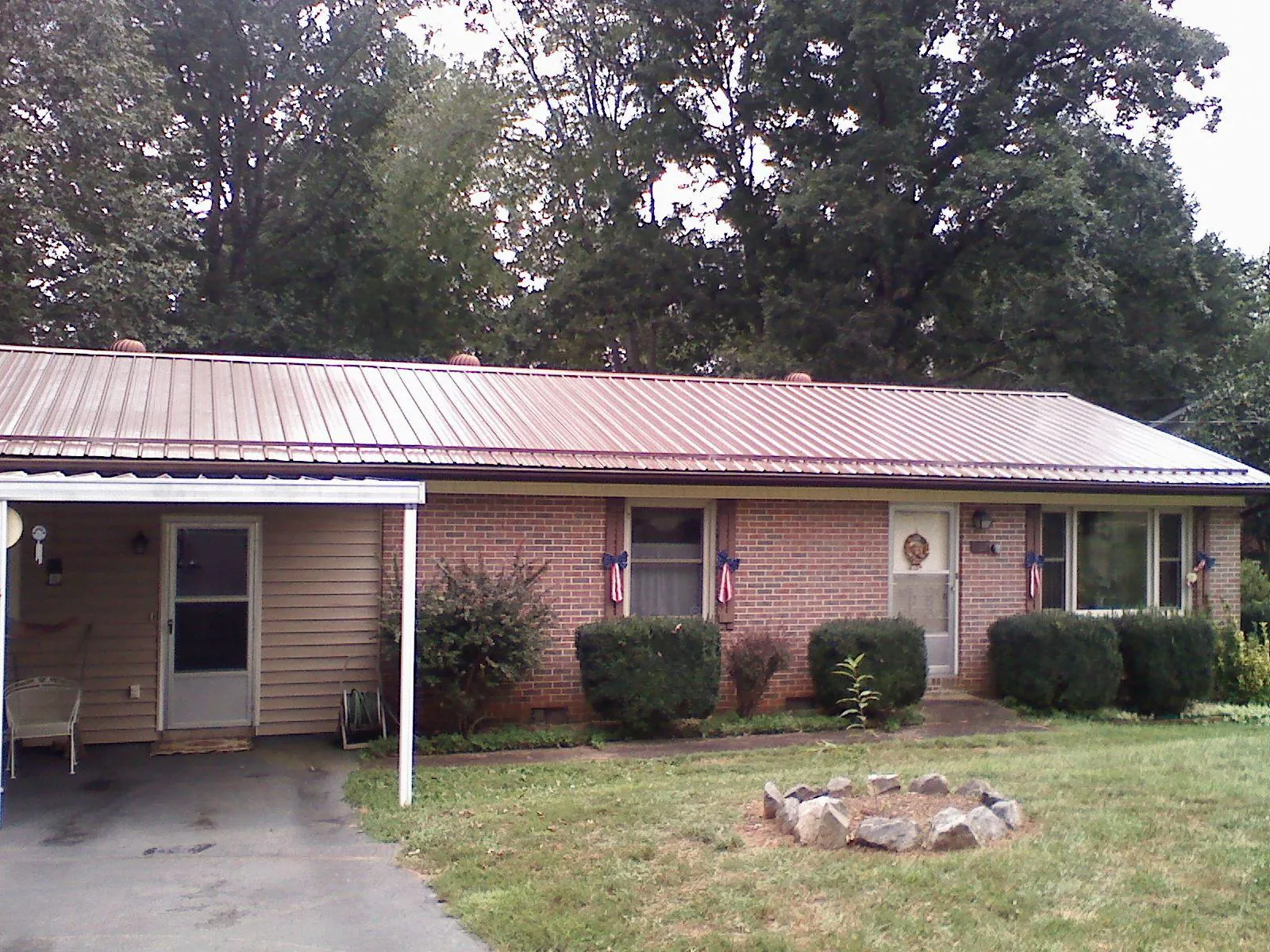 Bronze metal roof and carport on a brick ranch home — Roof Repair work by our crew in Denham Springs